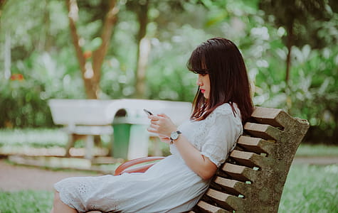Woman Sitting on Bench Checking Her Phone thumbnail