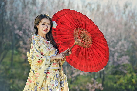 woman in beige floral dress holding oil paper umbrella thumbnail