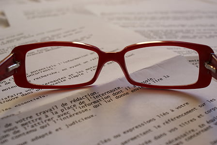 clear eyeglasses with red frames on top of book page thumbnail