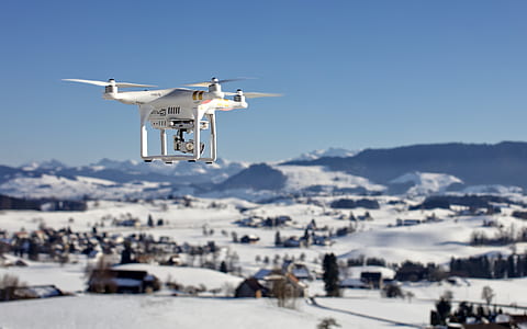 white DJI drone floating over houses during daytime thumbnail