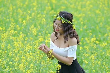 woman in white and black dress standing in flower field thumbnail
