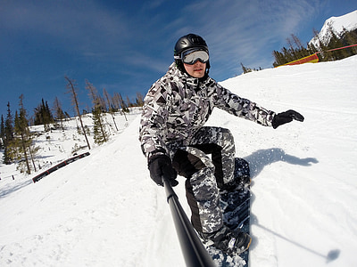 man snowboarding holding selfie stick thumbnail