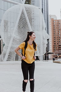 smiling woman in yellow shirt wearing backpack thumbnail
