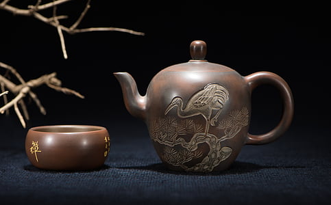 brown teapot near bowl on blue surface thumbnail