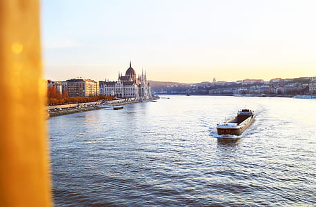 brown ship on water between buildings thumbnail