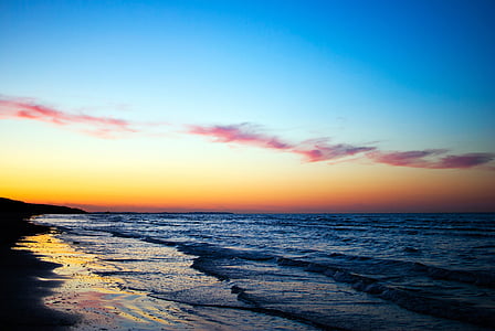 blue sea waves under orange sky thumbnail