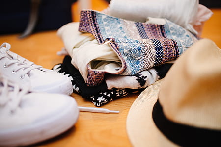 closeup photo of shoes, clothes, and hat on wooden surface thumbnail