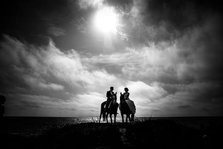 Grayscale Photography of Couple Riding on Horse With Body of Water and Sky As Background thumbnail