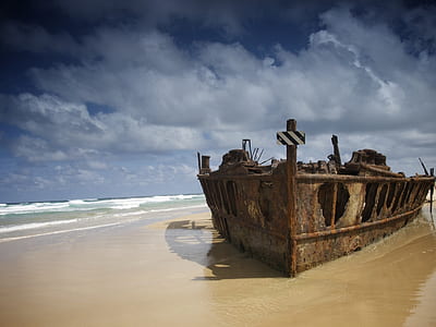 brown boat beside seashore thumbnail