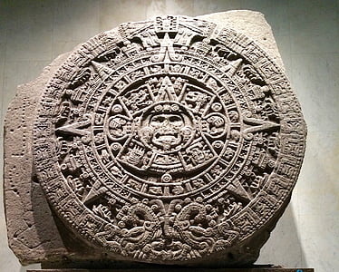 selective focus photography of stone Mayan calendar inside room thumbnail