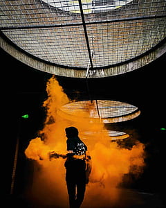 person in black hoodie standing next to orange smoke thumbnail