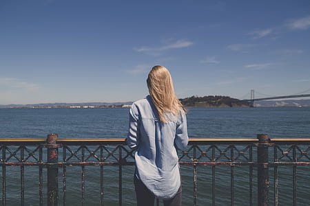 woman standing near body of water thumbnail