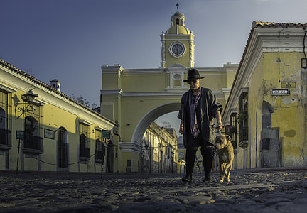man and dog beside building during daytime thumbnail