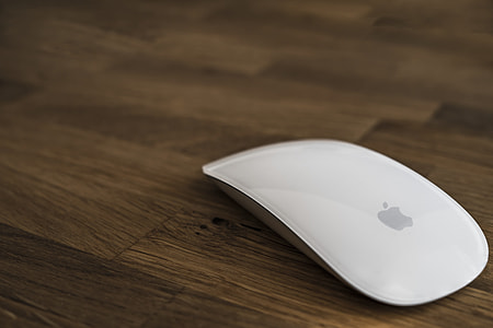 Apple Magic Mouse on brown wooden surface thumbnail