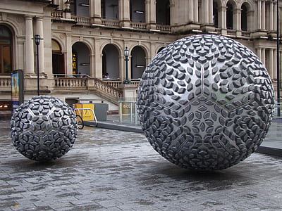 close-up photography of two gray ball statue at daytime thumbnail