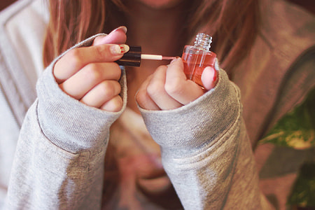 woman holding nail polish thumbnail