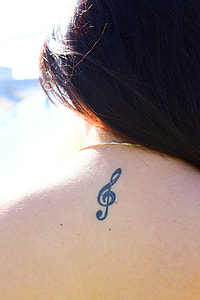woman with song note tattoo behind the neck thumbnail