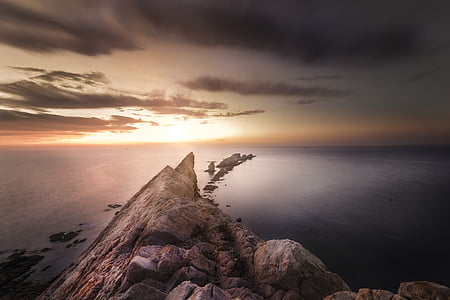 gray rock formation near body of water thumbnail