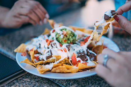 person taking some nachos on plate thumbnail