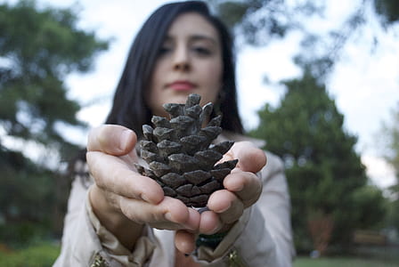 woman holding plant during daytime thumbnail