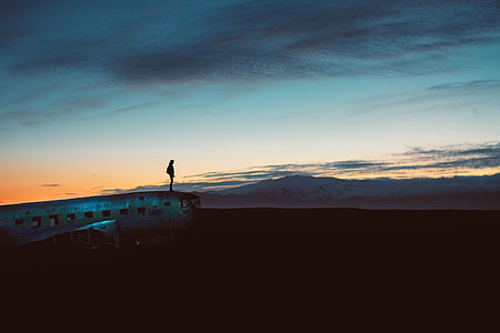 silhouette photo of person standing on plane during dawn thumbnail