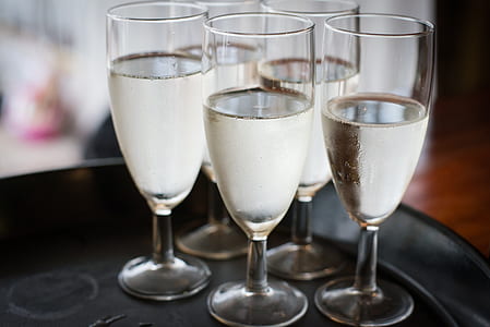five clear long-stem wine glasses with liquids thumbnail