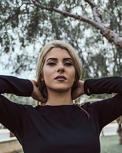 woman fixing hair outdoor during daytime thumbnail