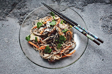 noodles with vegetables in glass bowl with chopsticks thumbnail