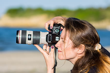 woman holding black and grey DSLR camera while taking pictures thumbnail