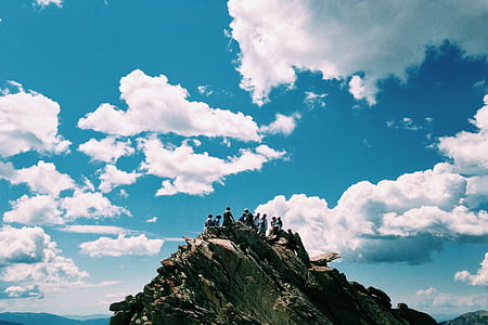 group of people standing on peak of mountain under clear blue sky during daytime thumbnail