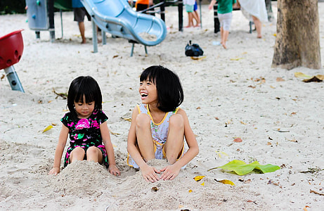 kid's sitting on brown sand thumbnail