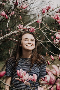 woman standing near pink flowering tree thumbnail
