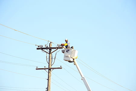 person standing inside the boom beisde electric post thumbnail