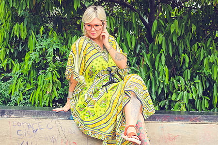 Woman Sitting on Side Pavement Wall Holding Her Ears thumbnail