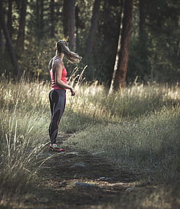 woman standing on forest during daytime thumbnail