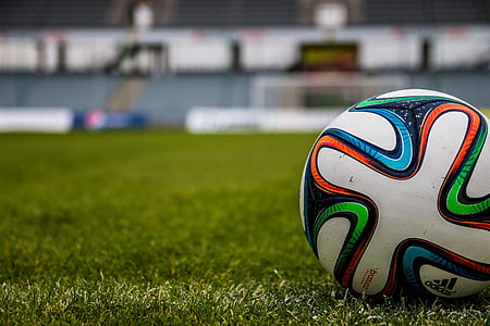 white and green soccer ball on green grass field thumbnail