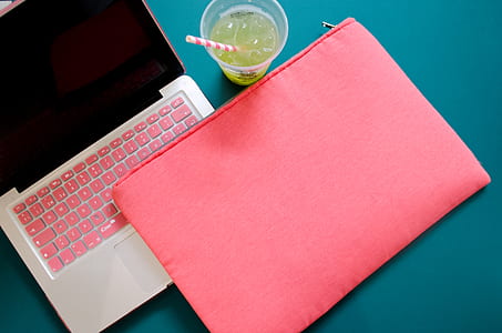 pink fabric pouch on gray laptop computer placed on green panel thumbnail
