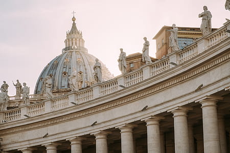 white concrete buildings with statues on balcony thumbnail