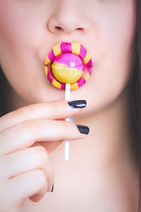 Woman Eating Pink and Yellow Lollipop thumbnail