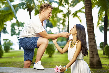 man wearing t-shirt touching woman chin while standing during daytime thumbnail