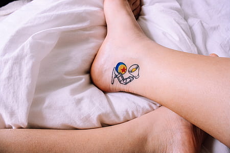 person with foldable lamp tattoo on ankle thumbnail