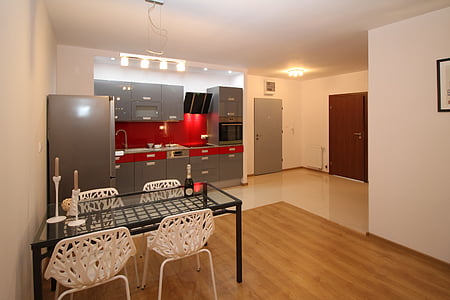 rectangular black metal-framed glass top dining table with four chairs on brown parquet flooring thumbnail