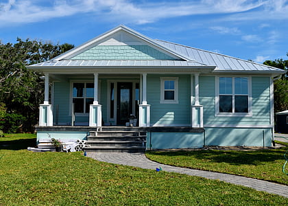 white and teal wooden house near tree at daytime thumbnail