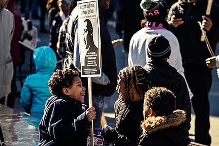 boy holding banner during daytime thumbnail