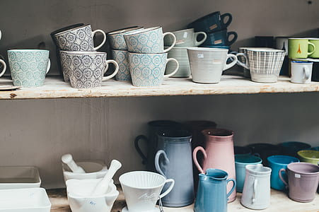 assorted-color ceramic mugs on shelf thumbnail