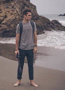 man holding camera standing in seashore thumbnail