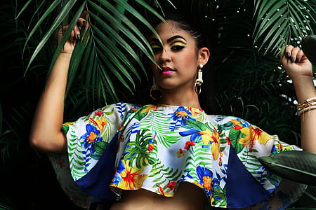 woman wearing crop top holding palm leaves thumbnail