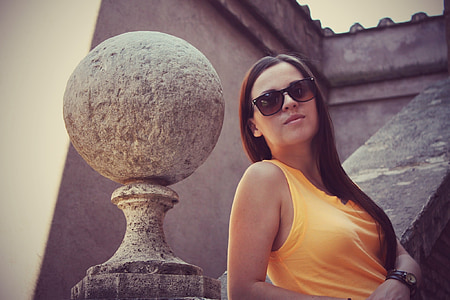 woman wearing orange tank top leaning on stairway thumbnail