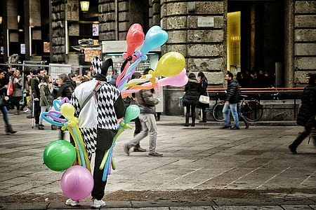 selective color photo of jester holding balloons thumbnail