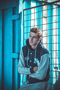 man wearing drawstring jacket lean on a wired screen thumbnail